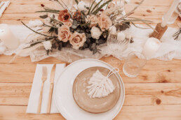 Houten tafel met bohemian bloemstuk, kaarsen en kandelaars van Casa